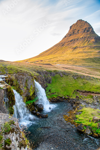 Iconic Kirkjufellsfoss waterfalls and Iceland landscape at golden hour.