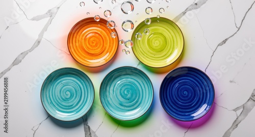 Colorful ceramic bowls arranged on a white marble surface