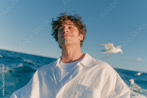 Relaxed Young Man Enjoying Ocean Breeze