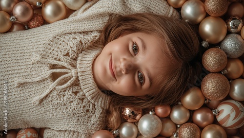 Girl Lying Among Shiny Holiday Ornaments and Decorations