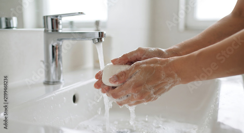 Hand washing with soap and water: A close-up shot of hands being washed with soap and water under a faucet, emphasizing hygiene and cleanliness.