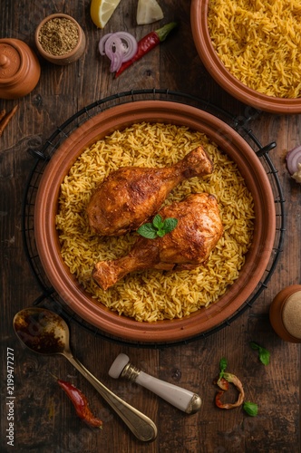 Chicken Drumsticks Served With Yellow Rice in a Traditional Dish