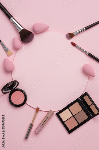 Makeup Tools and Products Arranged on a Pink Background for Beauty and Cosmet...