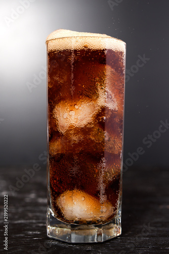 Misted cool glass with a glass of Coke, Pepsi, rum, alcohol ice cubes on a black background