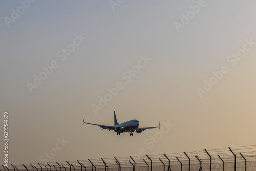 Commercial passenger airplane approaching landing at the runway airfield during calima haze