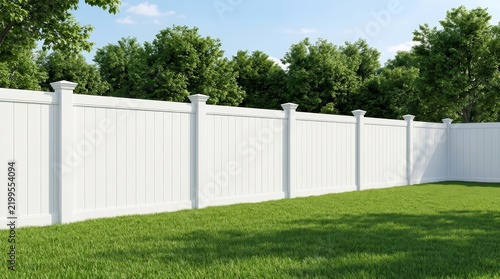 A clean backyard space featuring a white vinyl privacy fence and green grass.
