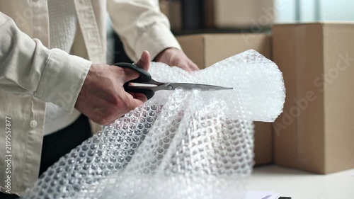 Person cuts bubble wrap with scissors