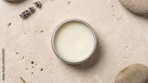 Natural lip balm or solid perfume in a metal tin on a stone background