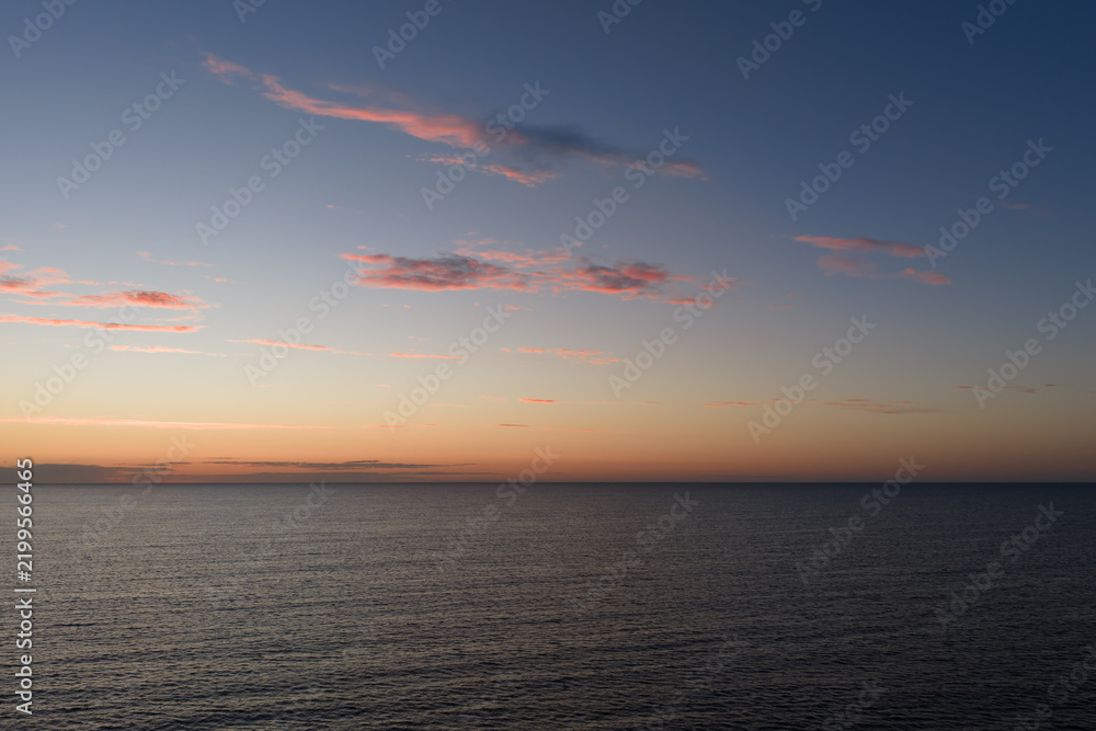 Obraz premium Aerial drone view of calm Baltic Sea water with light ripples under colorful sky with pink clouds after sunset in Estonia