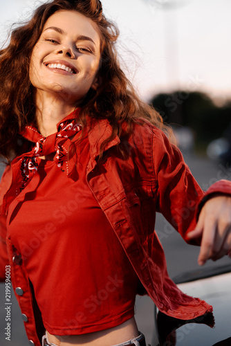 Fotografie Smiling woman in red jacket posing outdoors