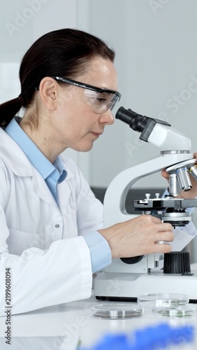 Obraz na płótnie Female scientist looking into a microscope