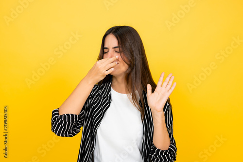 Bild auf Leinwand Young woman pinching her nose with a disgusted expression