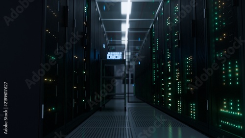 Moody server corridor illuminated by glowing led lights leading to a bright vanishing point inside a modern data center ideal for cloud computing and
