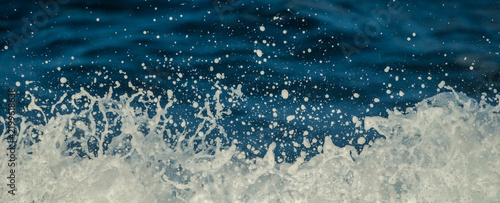 Obraz na płótnie Ocean Wave Splash with Sea Foam Droplets Against Deep Blue Water