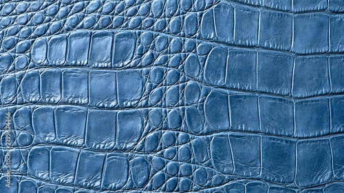 Blue crocodile skin leather texture background with dramatic lighting. Perfect for luxury fashion and accessory design backgrounds.