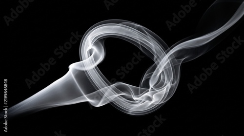 White smoke curls and swirls against a black background