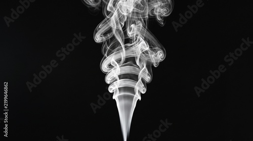 White smoke rises vertically against a black background