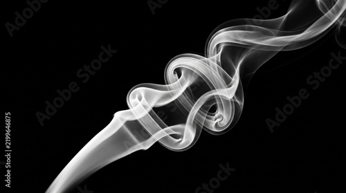 White vapor rises diagonally against a black background creating an abstract form