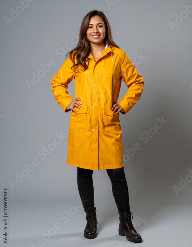 Woman smiling, wearing yellow raincoat for rainy weather