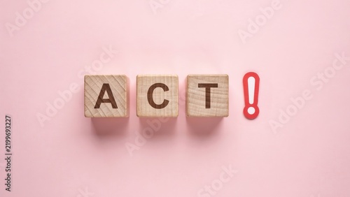 ACT word on wooden blocks with exclamation mark, motivational concept on pink background, call to action business message, proactive decision making