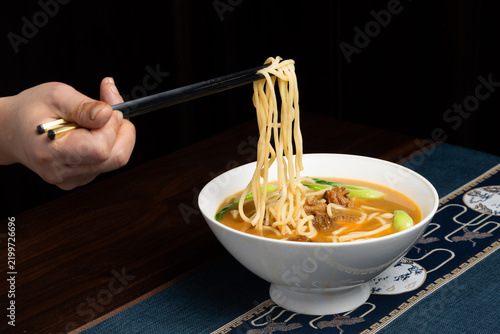 Chopsticks Lifting Beef Noodles. Chinese Braised Beef Noodle Soup Action Shot