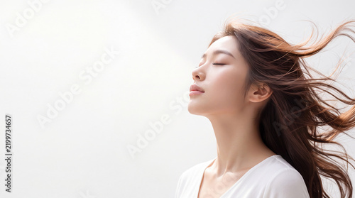 Naklejka 美しい長いストレートの髪をなびかせる若い日本人女性の横顔、コピースペース