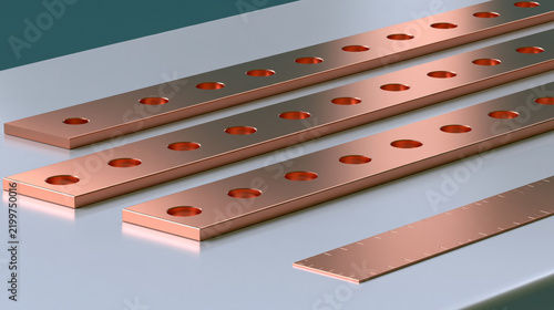 Three copper bars with circular openings on a work surface
