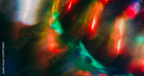 Bokeh ray. Light art. Defocused red blue multicolor radiant visual glisten optical neon glimmer texture circle on dark black background.