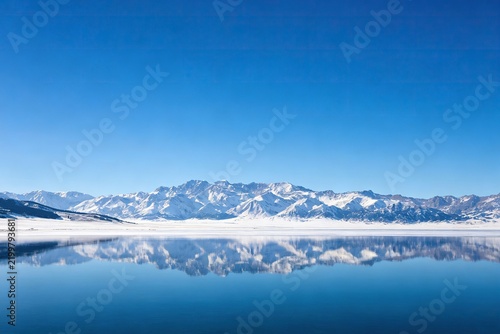 Snow-Capped Mountain Reflected in Calm Lake, Clear Blue Sky