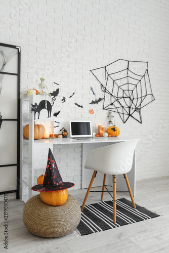 Interior of office decorated for Halloween with workplace and pumpkins