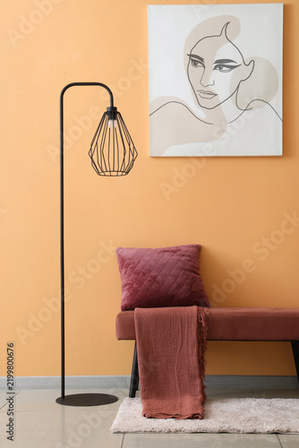 Interior of room with soft bench, lamp and painting