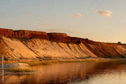 Sunset Lake Below Layered Eroded Sandy Cliffs