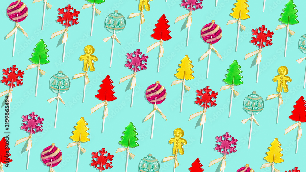 Obraz premium Christmas lollipops shaped Christmas tree, snowflake, gingerbread men, round baubles. Traditional handmade Christmas candies on stick as minimal banner. Xmas concept holiday colorful sweet candies.