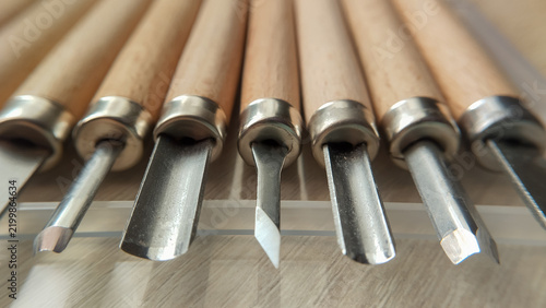 Bild auf Leinwand A neat row of specialized wood carving gouges and chisels showcasing their metallic cutting edges in a studio workshop