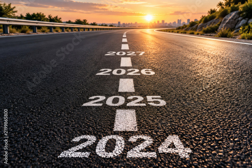 Road with years 2024 to 2027 marked leading towards a city skyline at sunset symbolizing future planning and goals