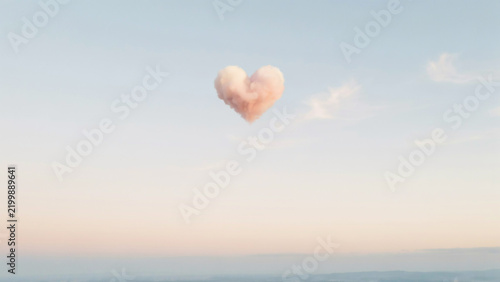 Delicate heart cloud in a soft pastel sky with subtle pink and blue hues