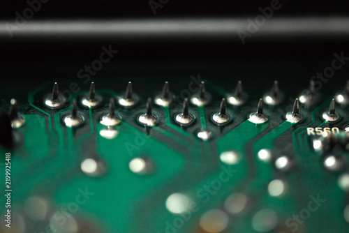 A macro close-up of an electronic car ECU revealing cold solder points, showing dull, cracked, and faulty connections on the circuit board.