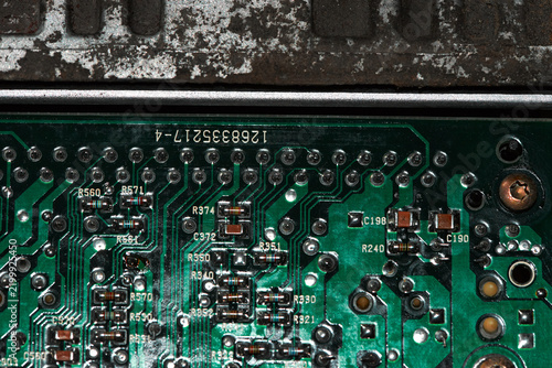 A macro close-up of an electronic car ECU revealing cold solder points, showing dull, cracked, and faulty connections on the circuit board.