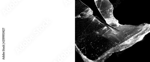Fotografie Broken glass shards on black background, shattered transparent crystal fragments
