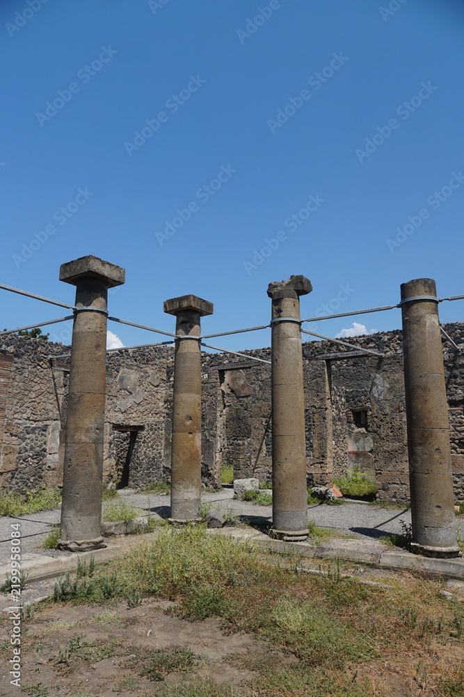 Obraz premium Ancient columns stand at the ruins of Pompeii