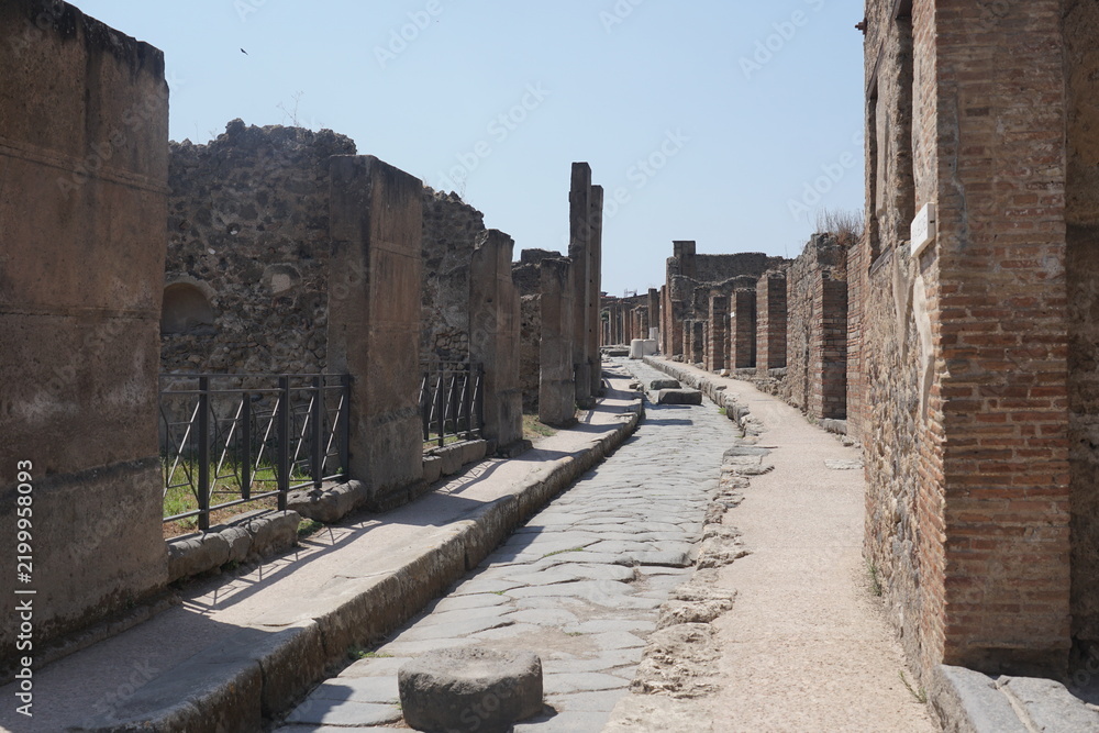 Obraz premium Ancient cobblestone street through the ruins of Pompeii