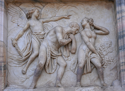 Relief of Adam and Eve expelled from Paradise on the facade of Milan Cathedral, Italy