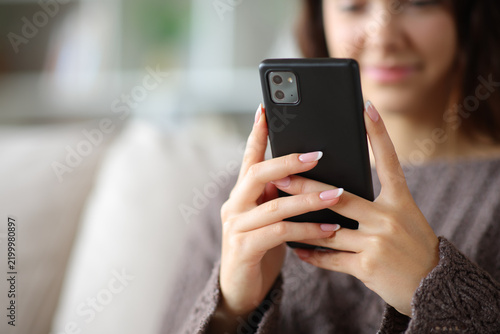 Woman hands holding and using smart phone at home