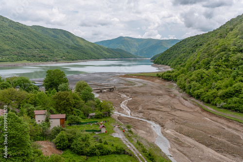 Принти на полотні A beautiful landscape featuring a lush green mountain rising above a calm river