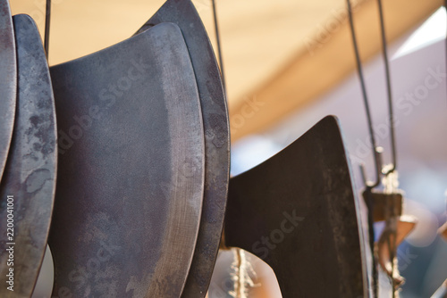 Obraz na plátně Forged Axe Blades Suspended on Display at a Market.