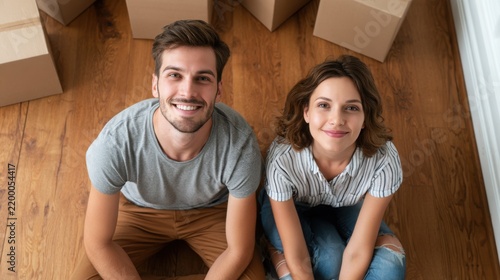 Happy Young Couple Sitting on Floor Dreaming About Their New Home and Furnishing