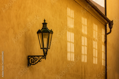 Vintage Lantern on Yellow Wall with Window Shadows in Golden Hour Sunlight,
