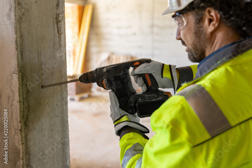Close-up of male worker drilling concrete