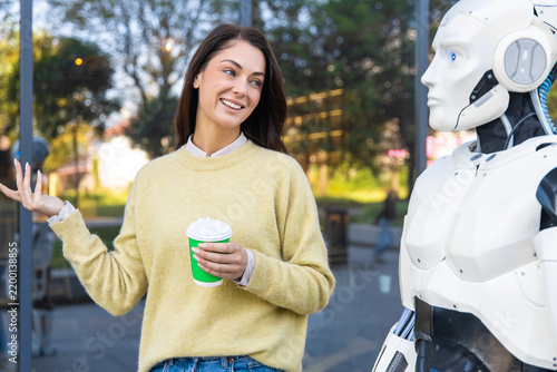 Cheerful woman gesturing while talking to android