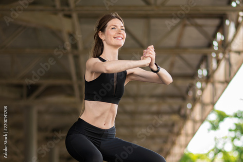 Obraz na plátne Young cute woman doing squats and exercises on her legs strengthening